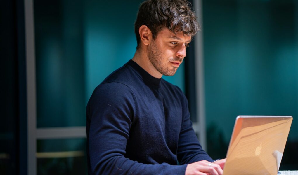 man in black long sleeve shirt using macbook